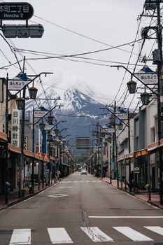 A picturesque street view of Mount Fuji framed by urban cityscapes in Yokosuka, Japan.