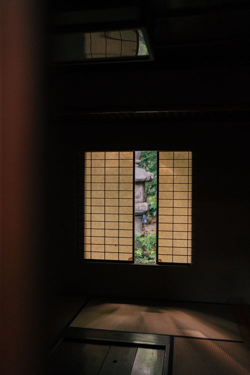 Free A serene view of a Japanese garden through shoji windows in a Kyoto-style room, showcasing traditional architecture. Stock Photo