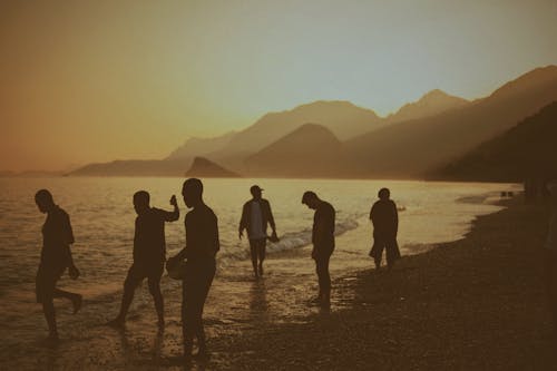 Free Group of People Standing on Shoreline Stock Photo