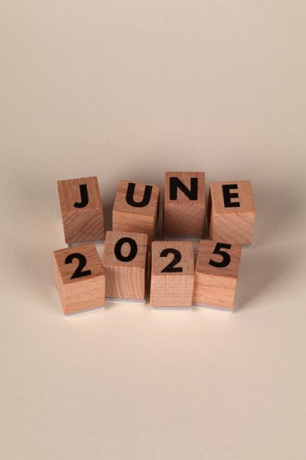 Wooden blocks arranged to show the date June 2025 on a neutral background.