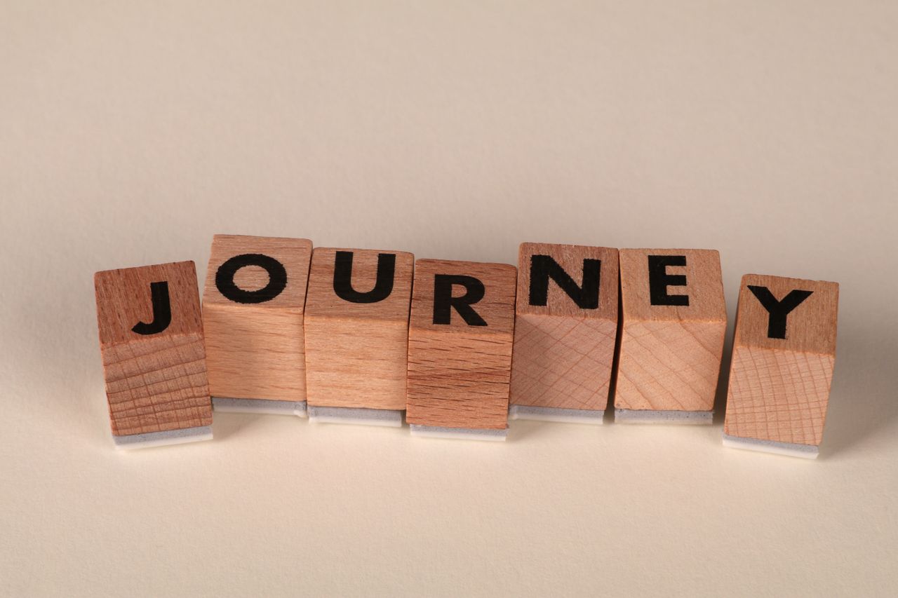 wooden blocks arranged to spell journey on a table symbolizing adventu