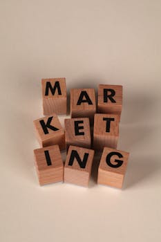 Wooden blocks arranged to spell 'MARKETING' on a neutral background.