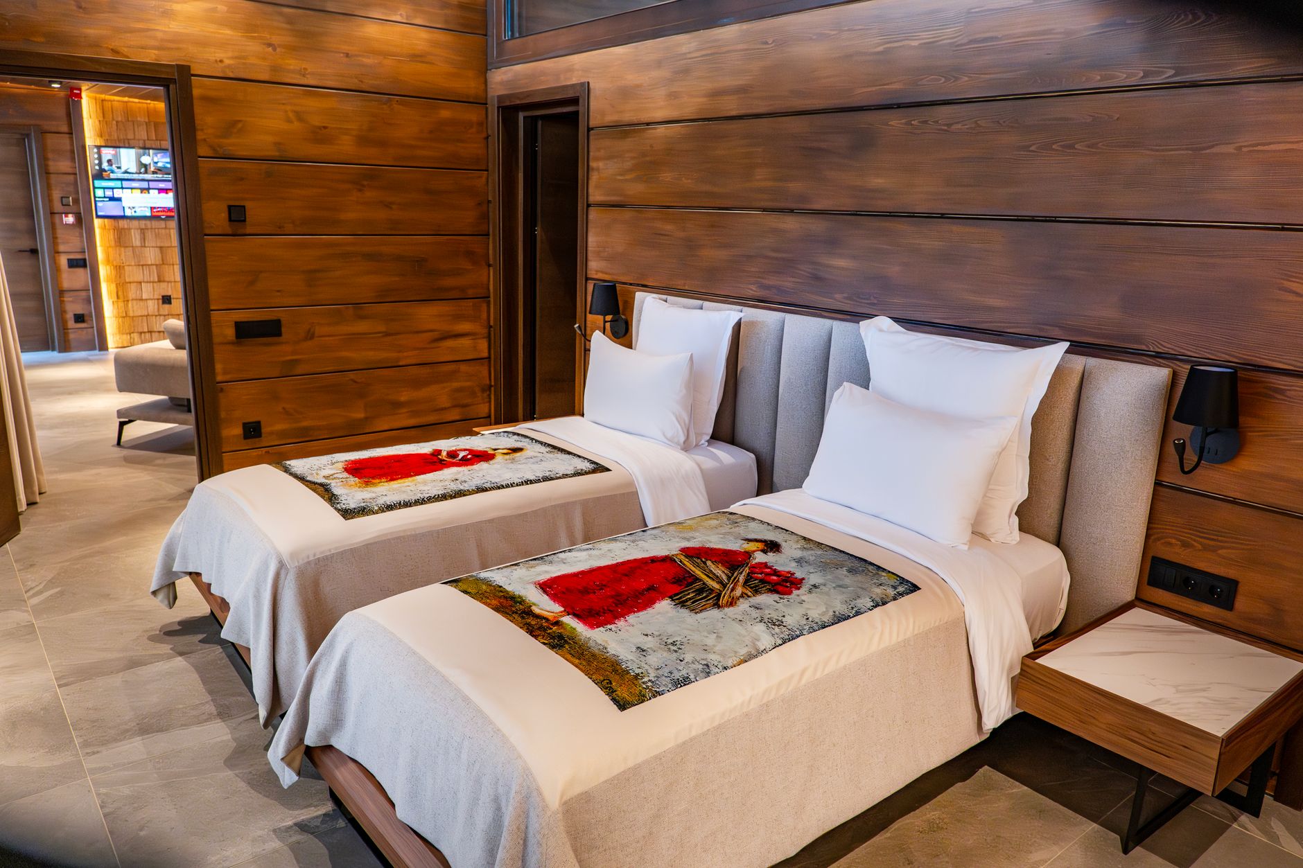 Cozy twin bedroom with wooden paneling and modern decor in a luxury Tbilisi hotel.