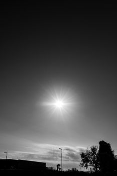 Dramatic black and white photo of an urban silhouette featuring a bright sunburst in Buenos Aires.
