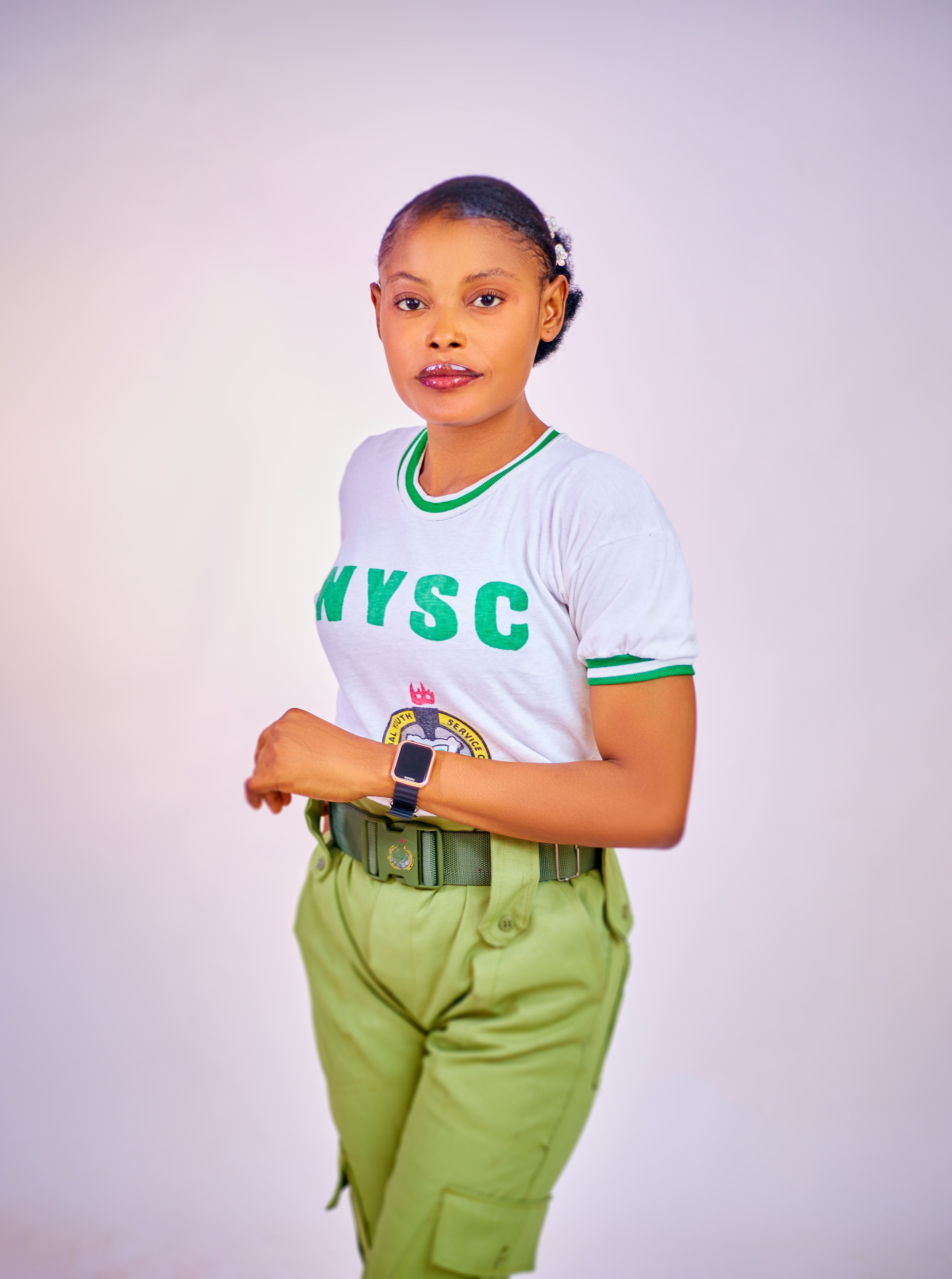 De franc Dona jove amb uniforme de NYSC posant amb confiança a l'interior. Foto d'estoc
