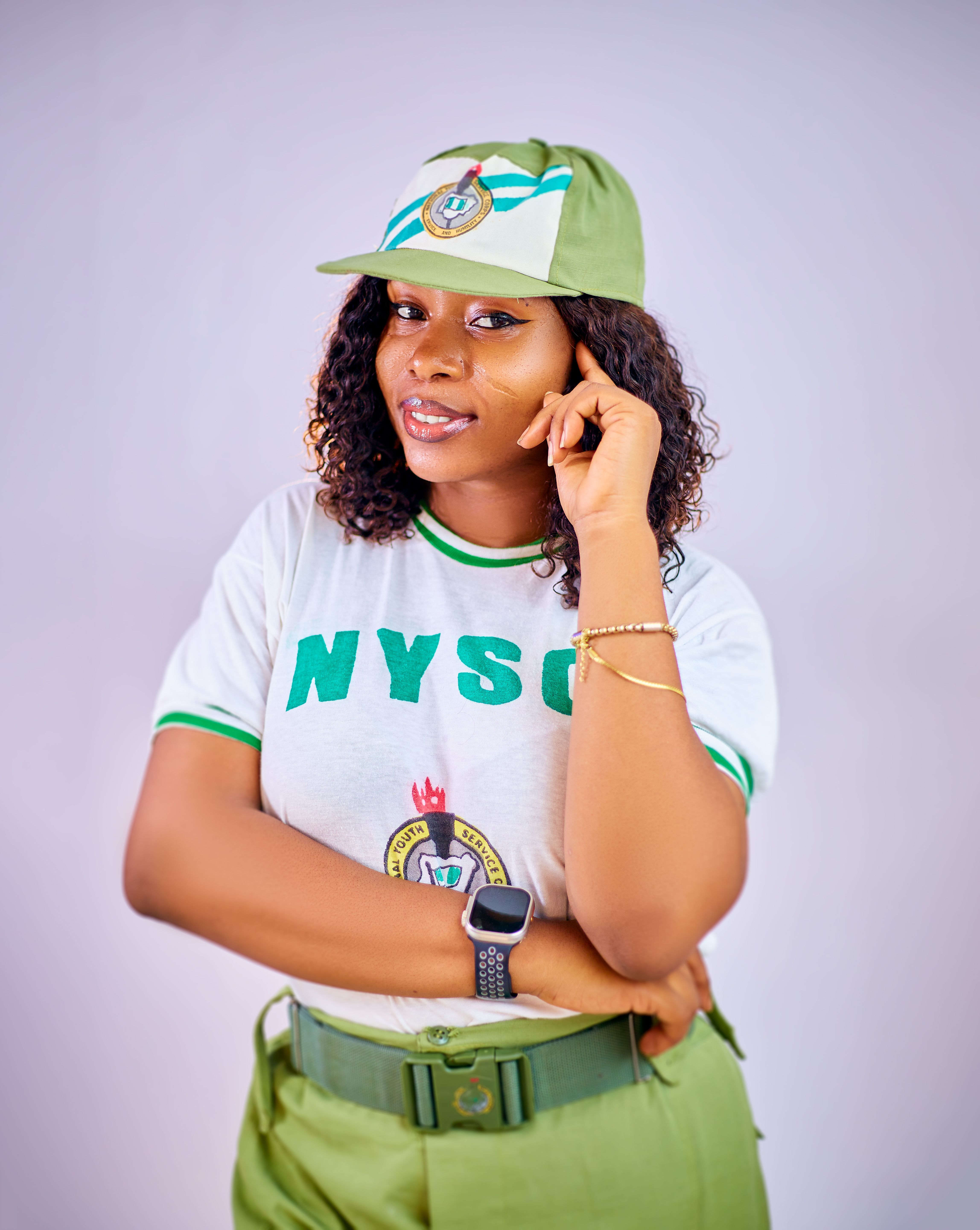 Young woman confidently posing in an NYSC uniform, showcasing pride and leadership.