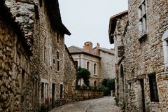 A serene cobblestone alley winds through a historic stone-built town, capturing traditional architecture.