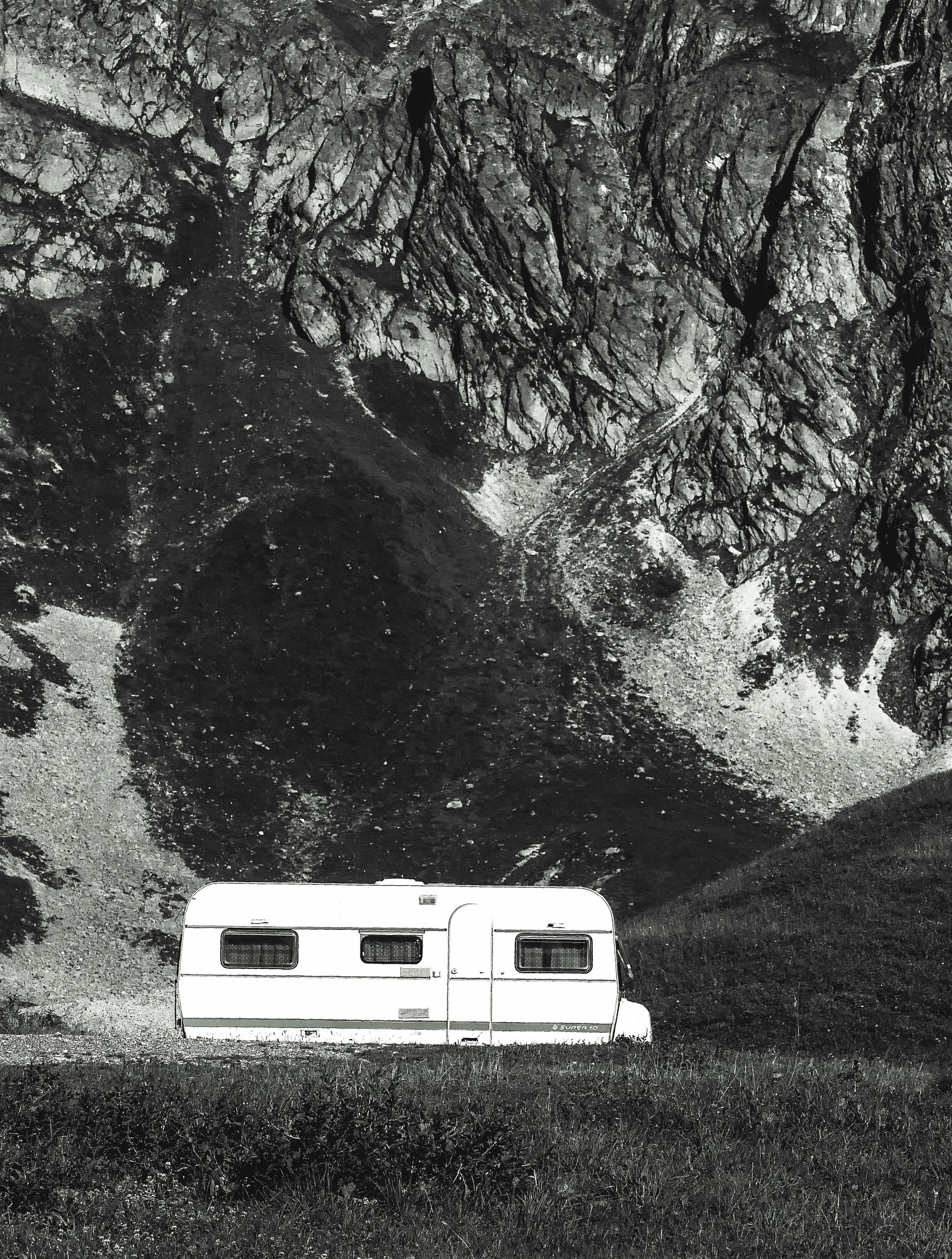 A caravan parked against the majestic mountain backdrop of La Plagne Tarentaise in France, capturing serene outdoor vibes.