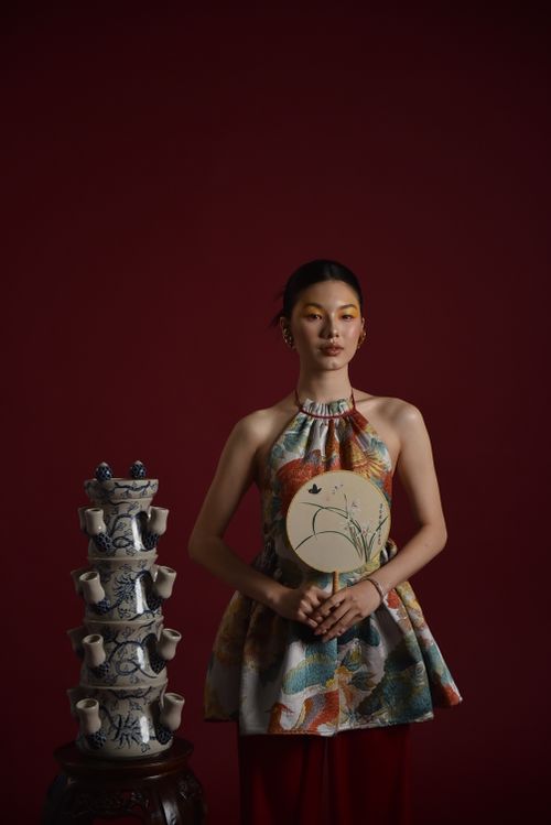 Free Portrait of an elegant Asian woman in traditional dress with ornate vases. Stock Photo