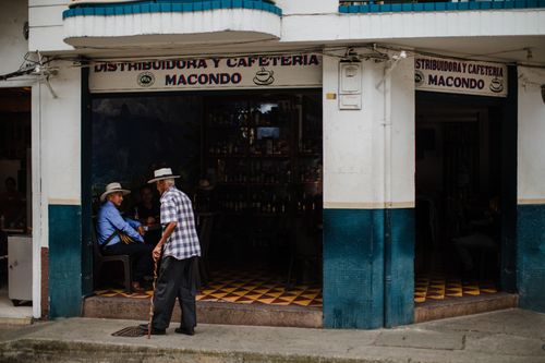 Free Charming street-side café in Jericó, Colombia, with locals enjoying a relaxed day. Stock Photo