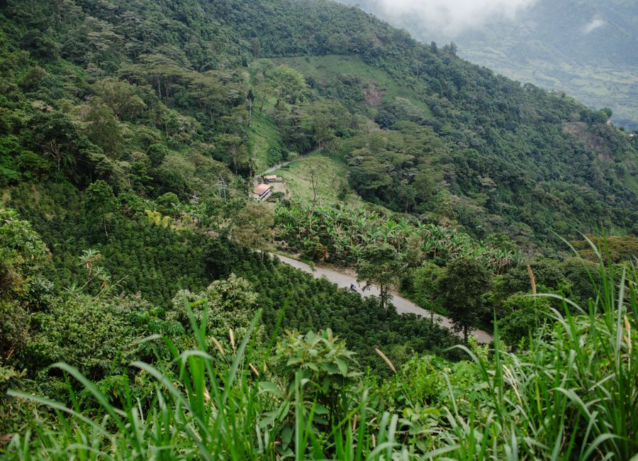 Stunning aerial view of lush green mountains and farm in Jericó, Antioquia, Colombia.