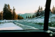 冬日景色宁静，山路白雪覆盖，针叶树点缀其间