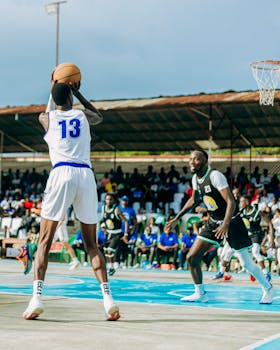 Dynamic action shot of a basketball player shooting, with opponents in pursuit.