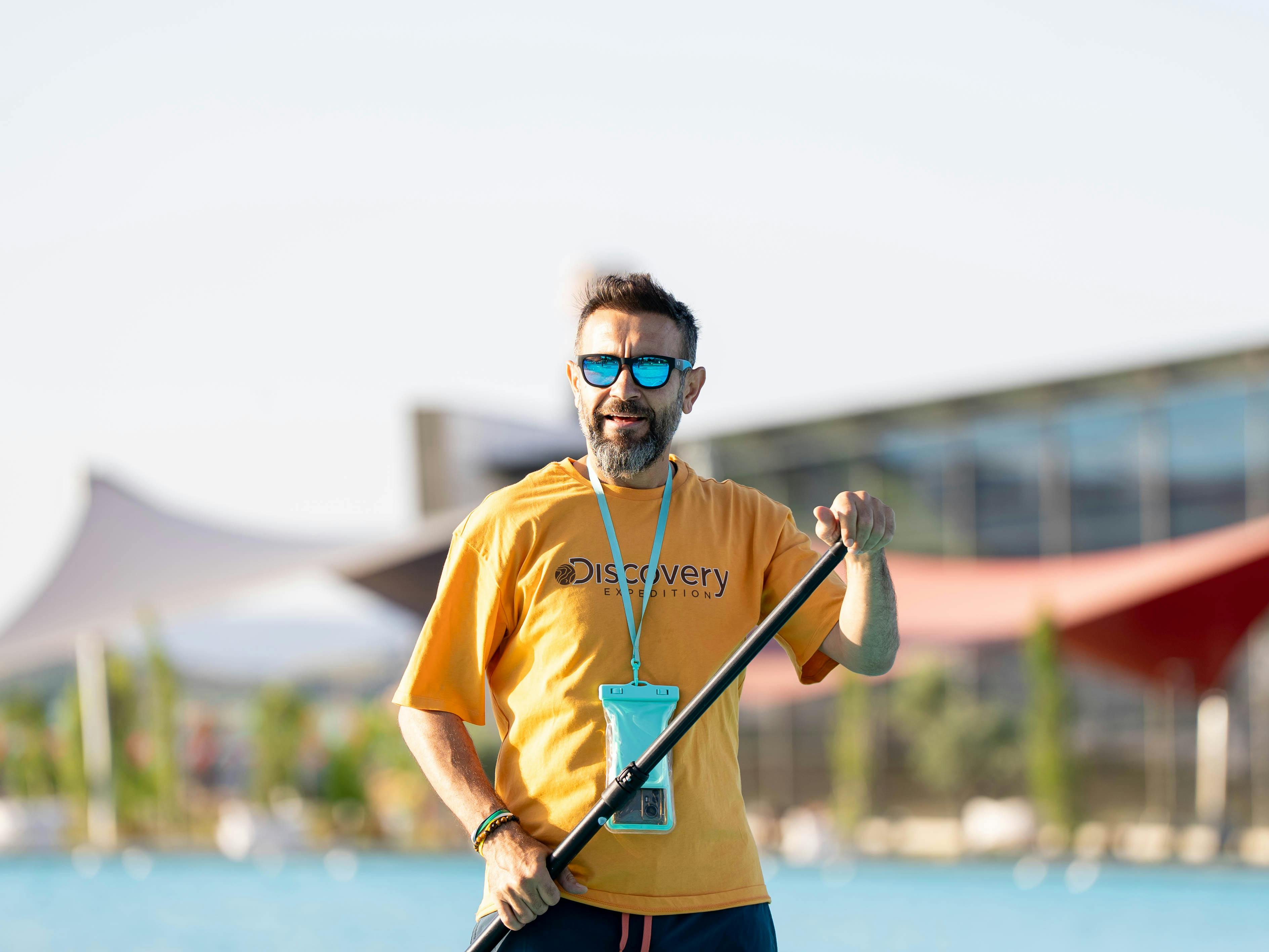 Adult male paddleboarding outdoors at a pool in sunny Kahramanmaraş, Türkiye.