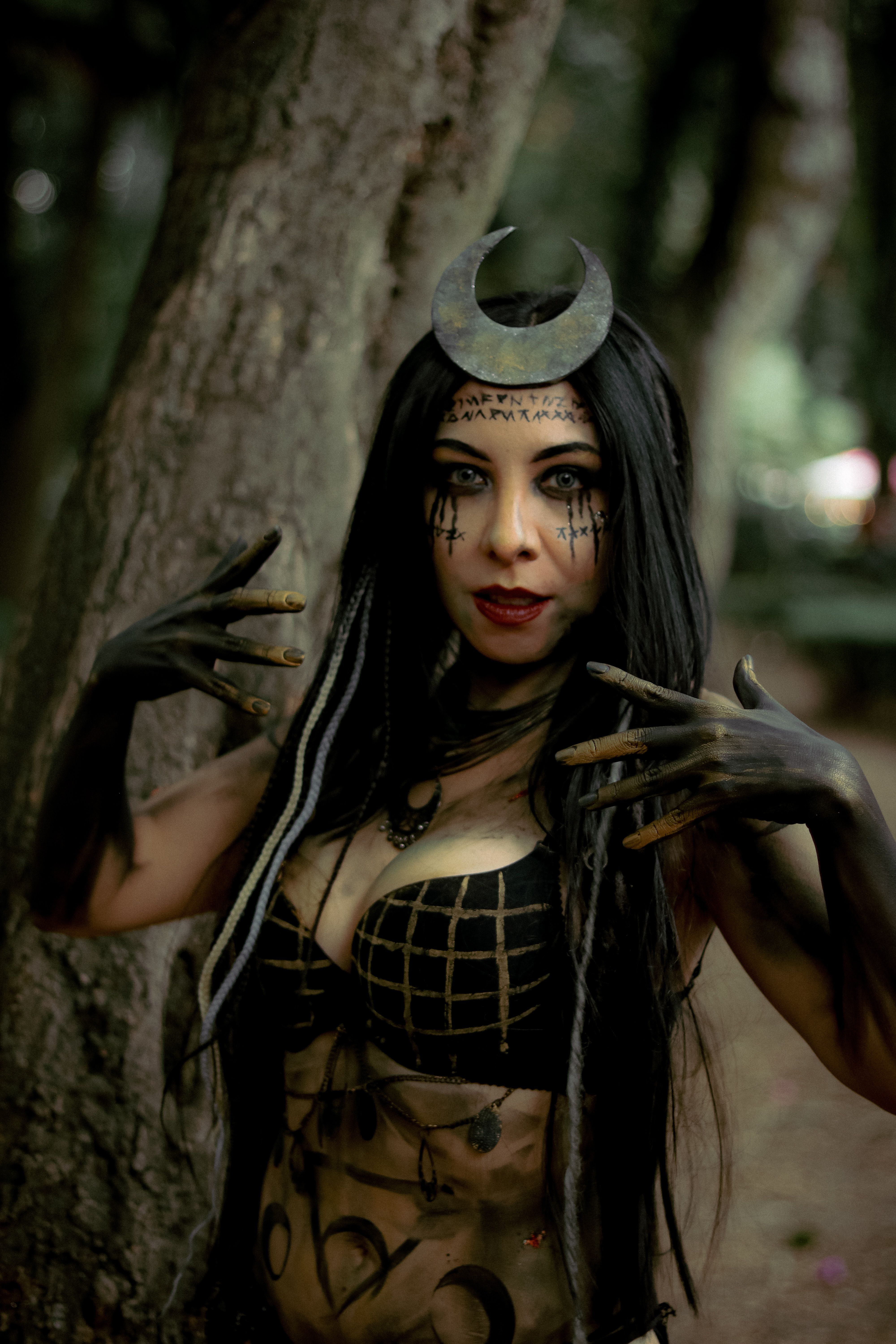 Intriguing portrait of a dark sorceress in a mystical forest setting, exuding mystery and magic.