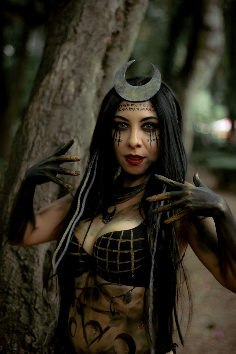 Intriguing portrait of a dark sorceress in a mystical forest setting, exuding mystery and magic.