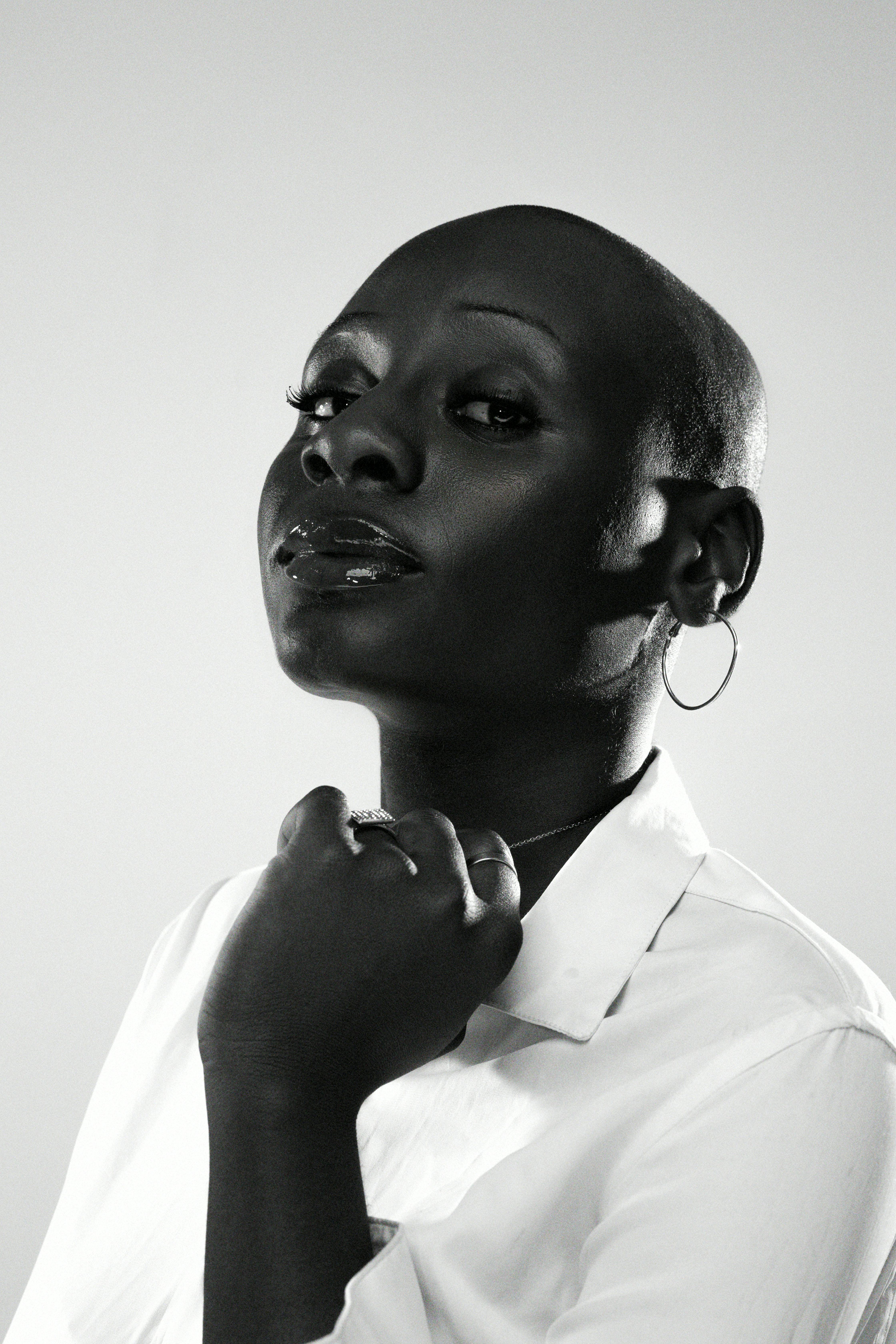 Striking black and white portrait of a confident woman with bold features and hoop earrings.