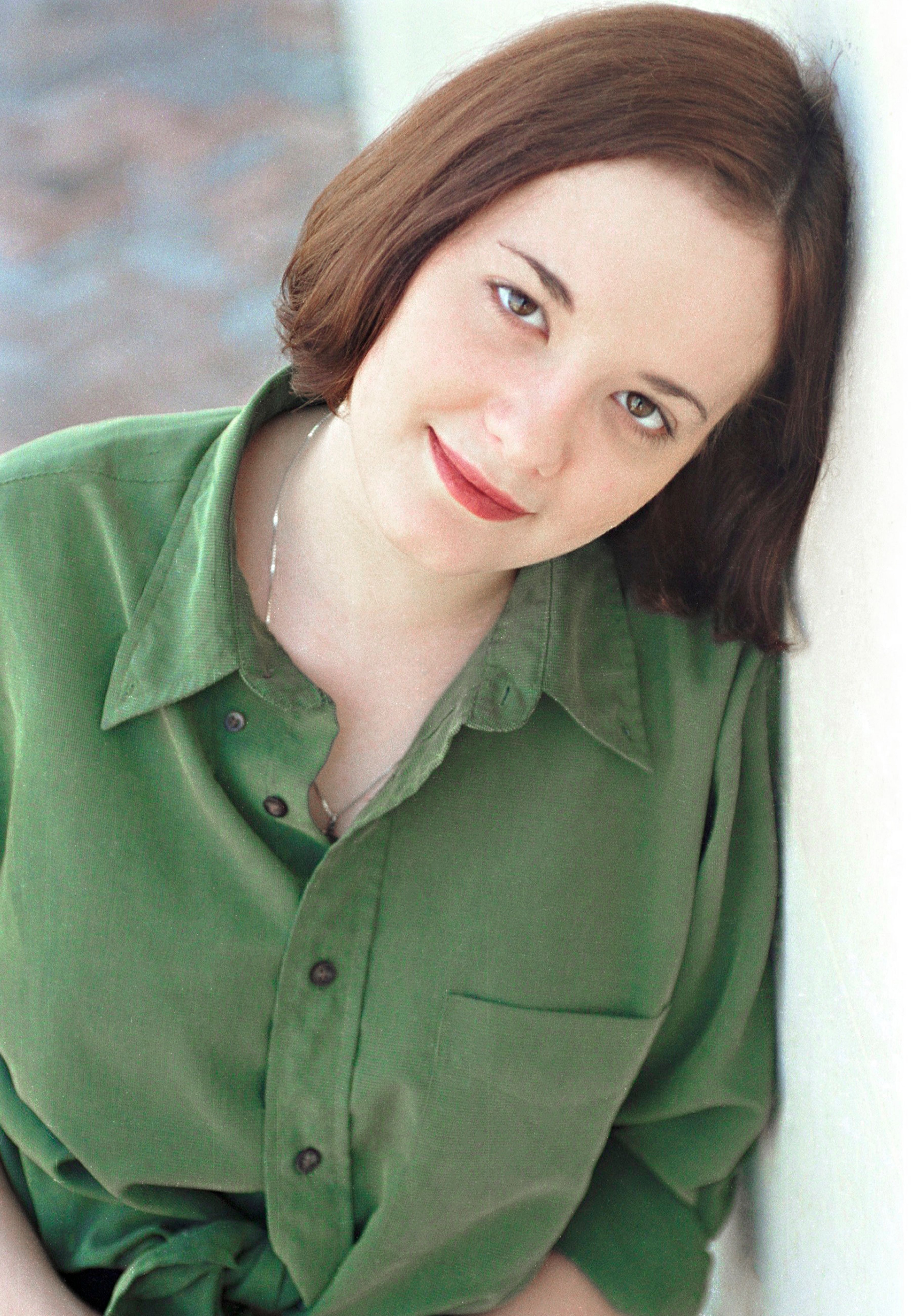 A candid portrait of a smiling woman in natural light, showcasing vintage aesthetics and relaxed atmosphere.