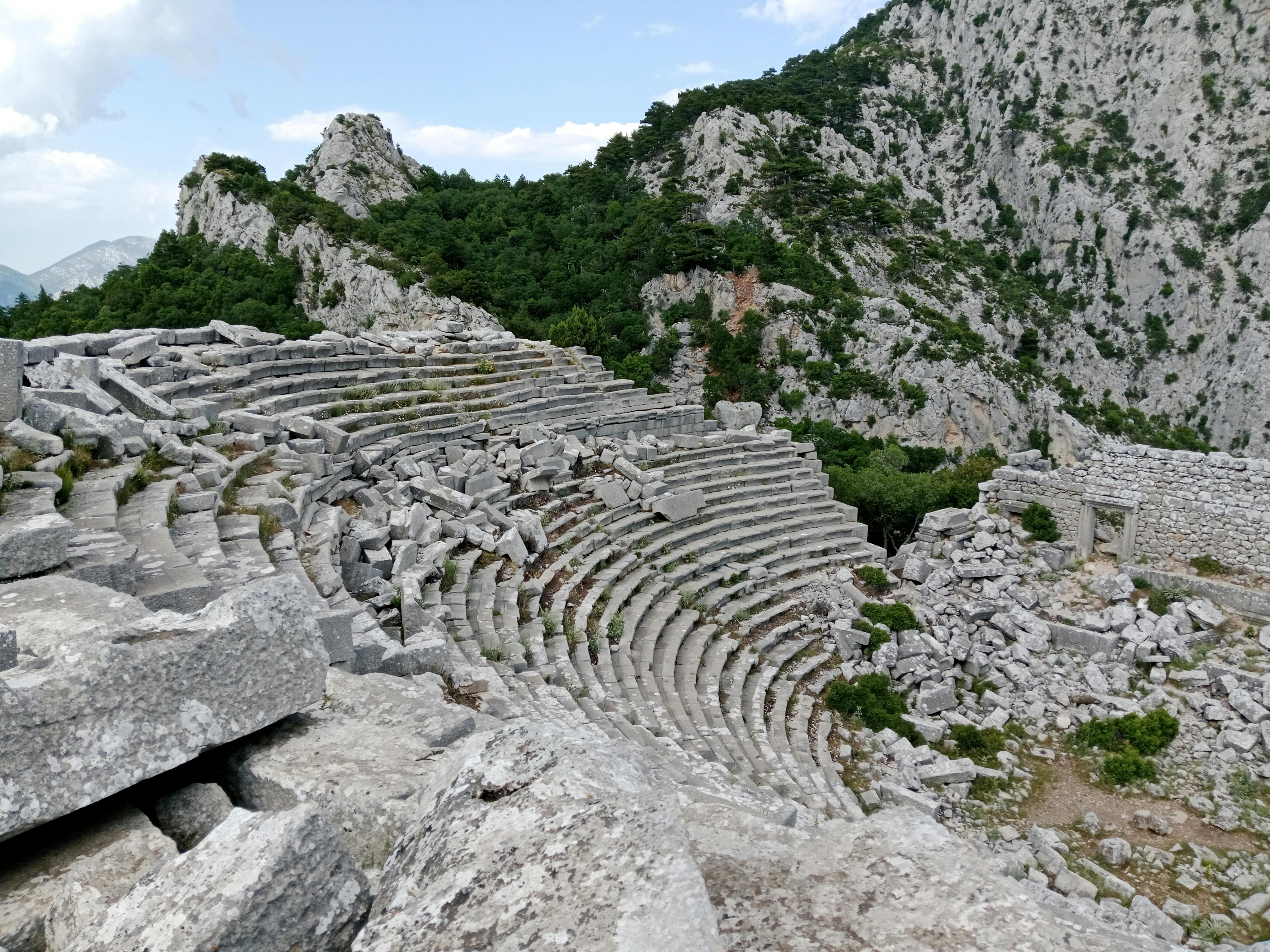 Gratis Rovine di un antico anfiteatro incastonato in un paesaggio montuoso roccioso. Foto a disposizione