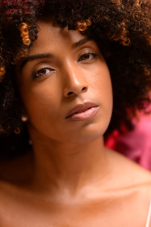 Free Close-up portrait of a woman with natural curly hair in warm lighting, São Paulo, Brazil. Stock Photo