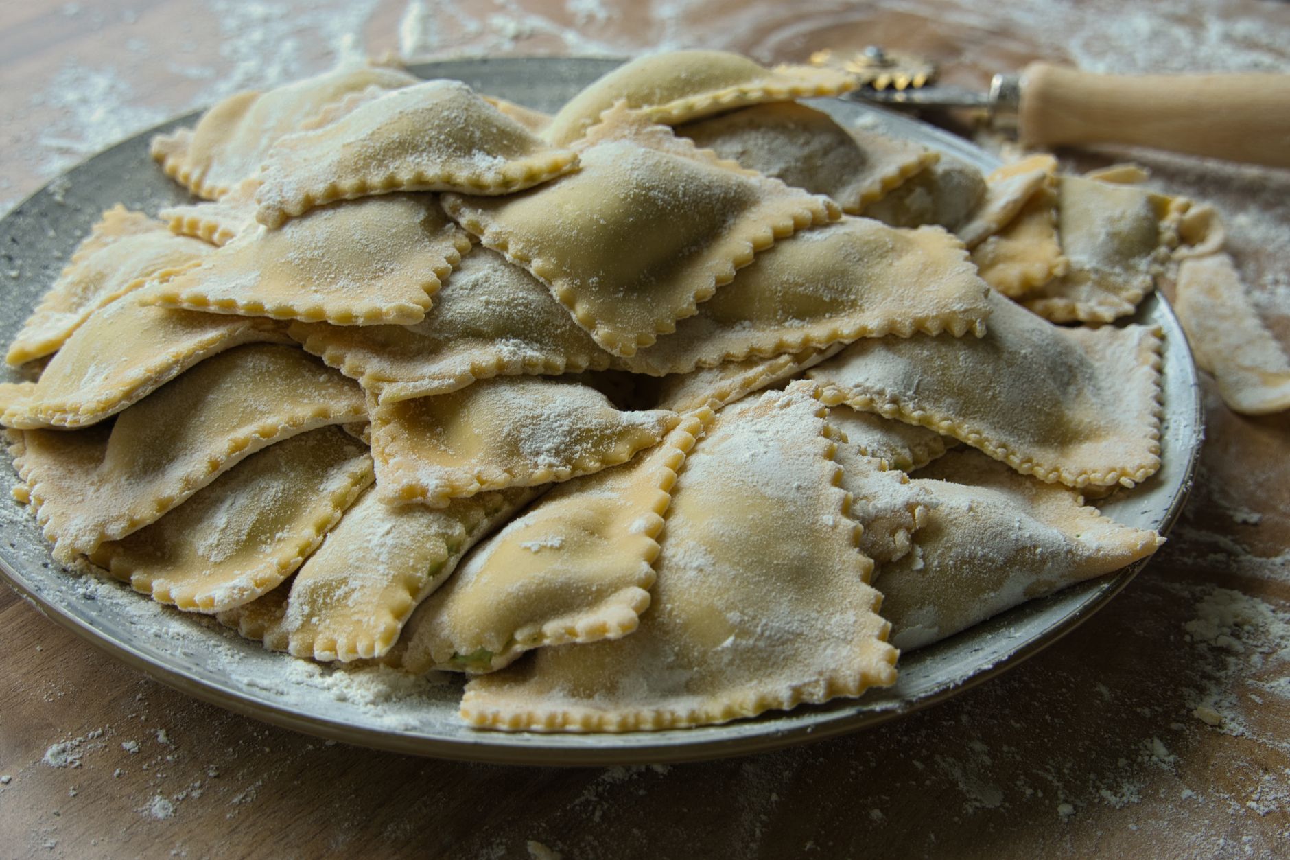 Freshly made butternut squash ravioli on floured tray