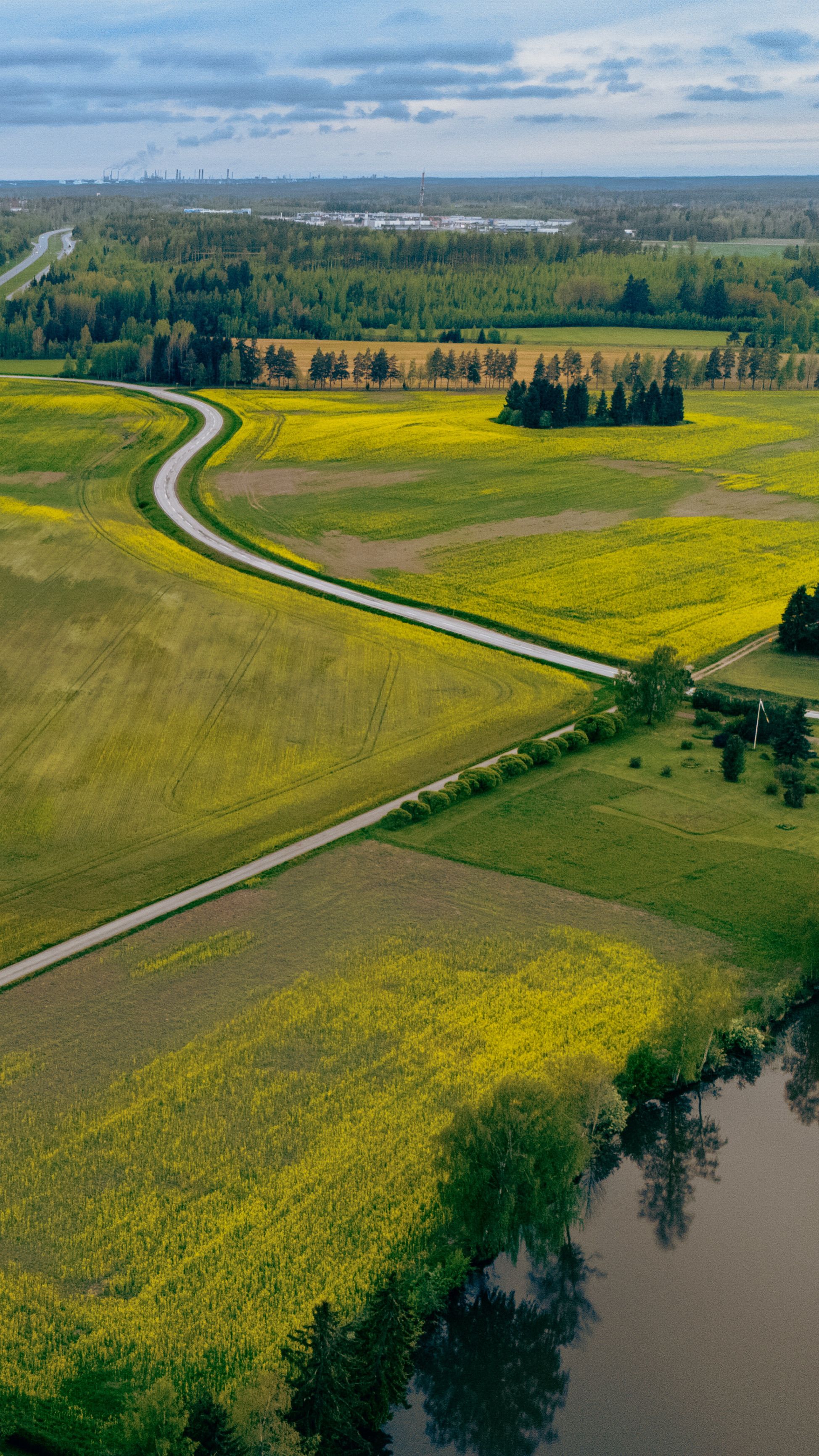 Explore the picturesque aerial landscape of Porvoo, Finland with lush fields and winding roads.