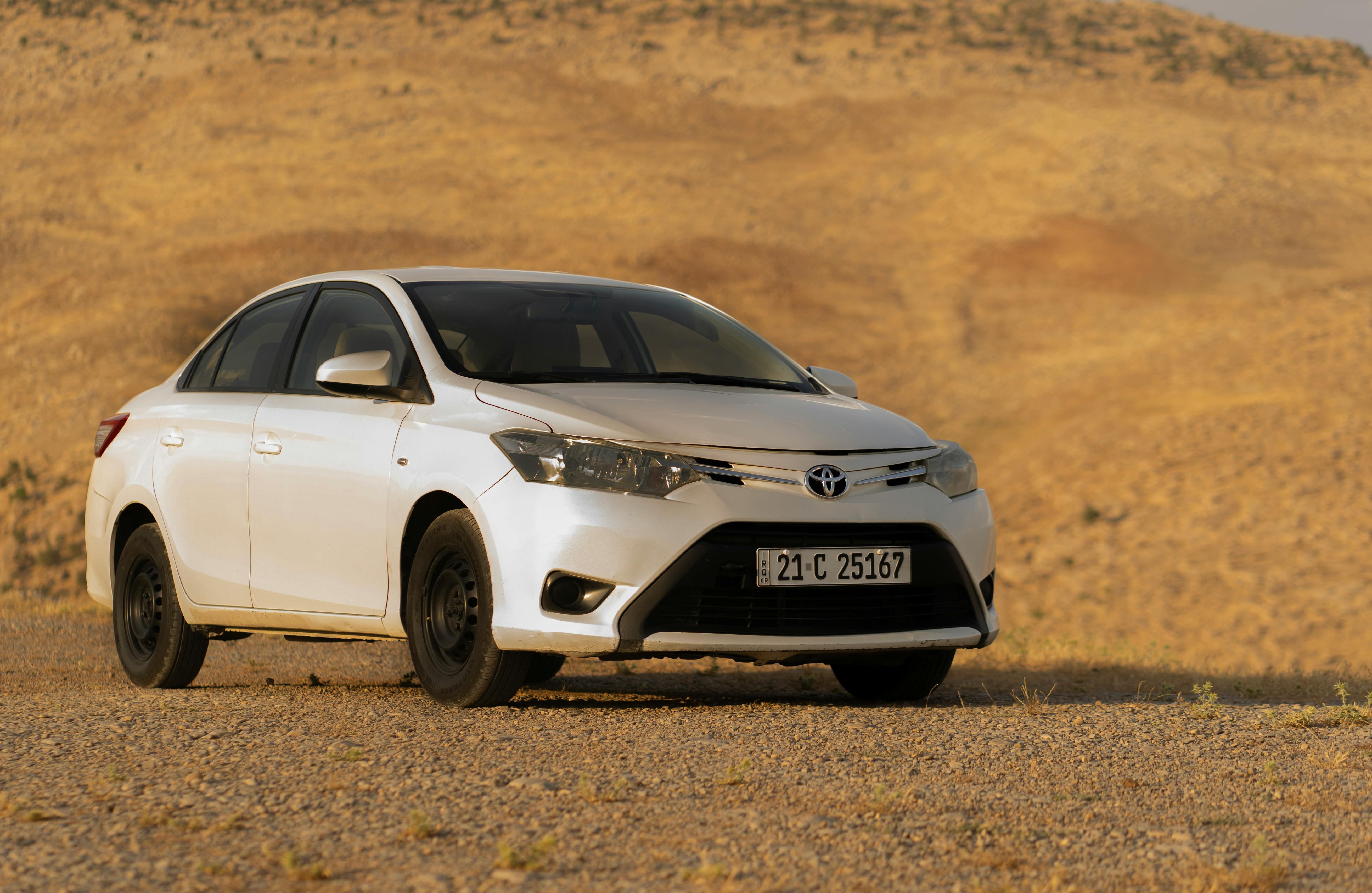 Free A modern white Toyota car parked in a vast desert setting, perfect for automotive imagery. Stock Photo