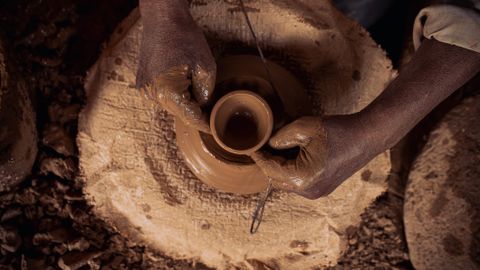 Close-up of hands shaping clay on a potter's wheel in Marrakech, Morocco.