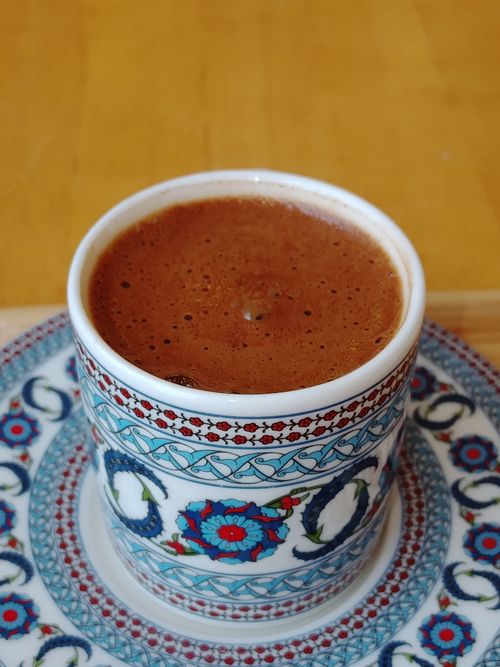 Free Close-up of Turkish coffee in a floral-patterned cup on a wooden table. Stock Photo