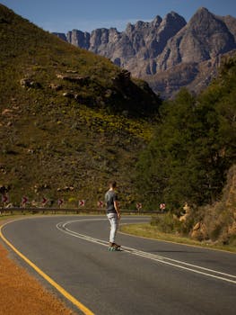 A skateboarder rides down a winding mountain road in Cape Town, South Africa.