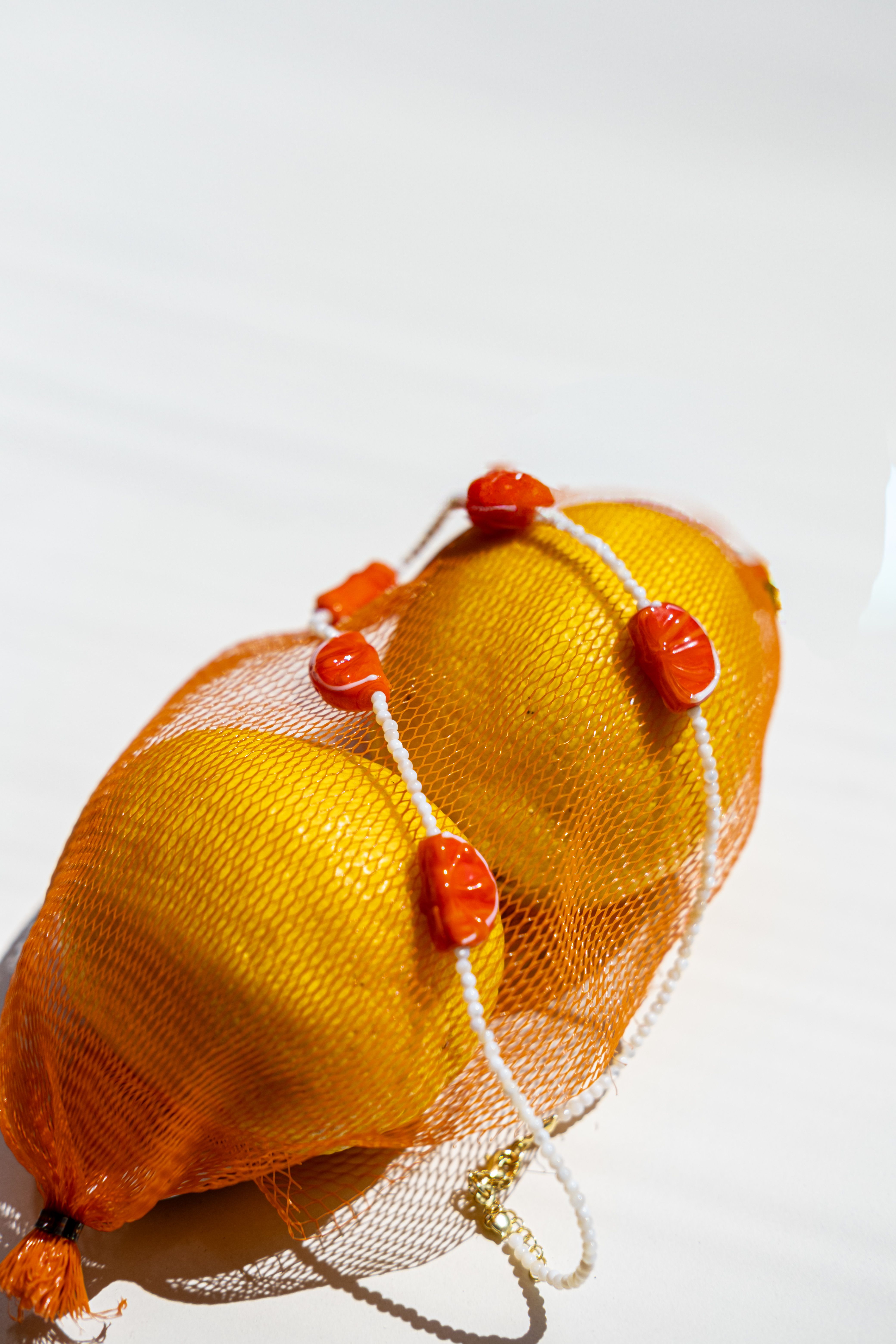 Fresh Lemons in Orange Mesh Bag on White Background · Free Stock Photo