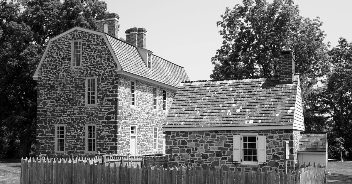 A vintage stone house with a picket fence on a sunny day in Horsham, Pennsylvania.