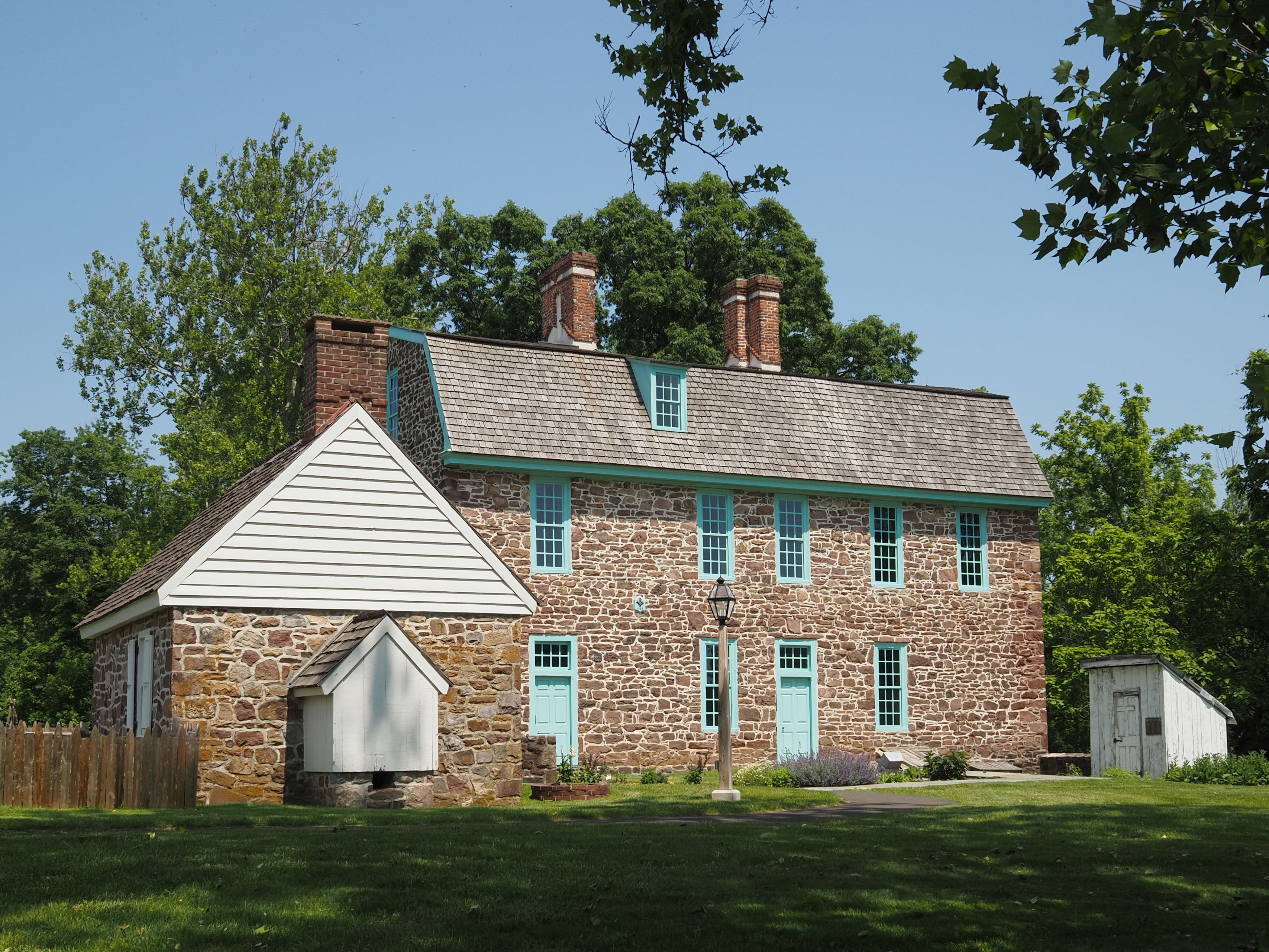 Historic Pennsylvania stone house surrounded by summer greenery
