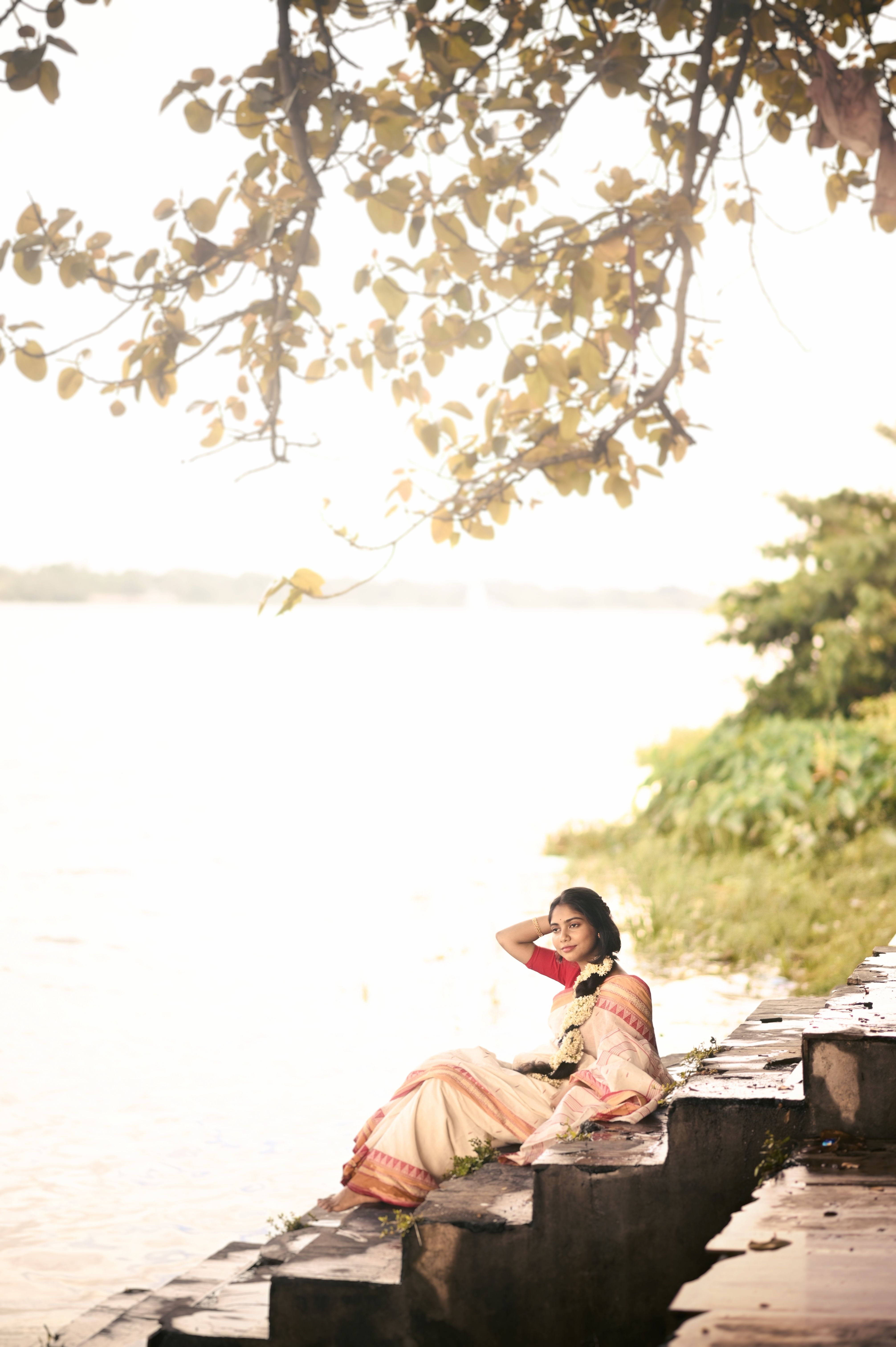 Woman Relaxing by Riverside in Traditional Saree · Free Stock Photo