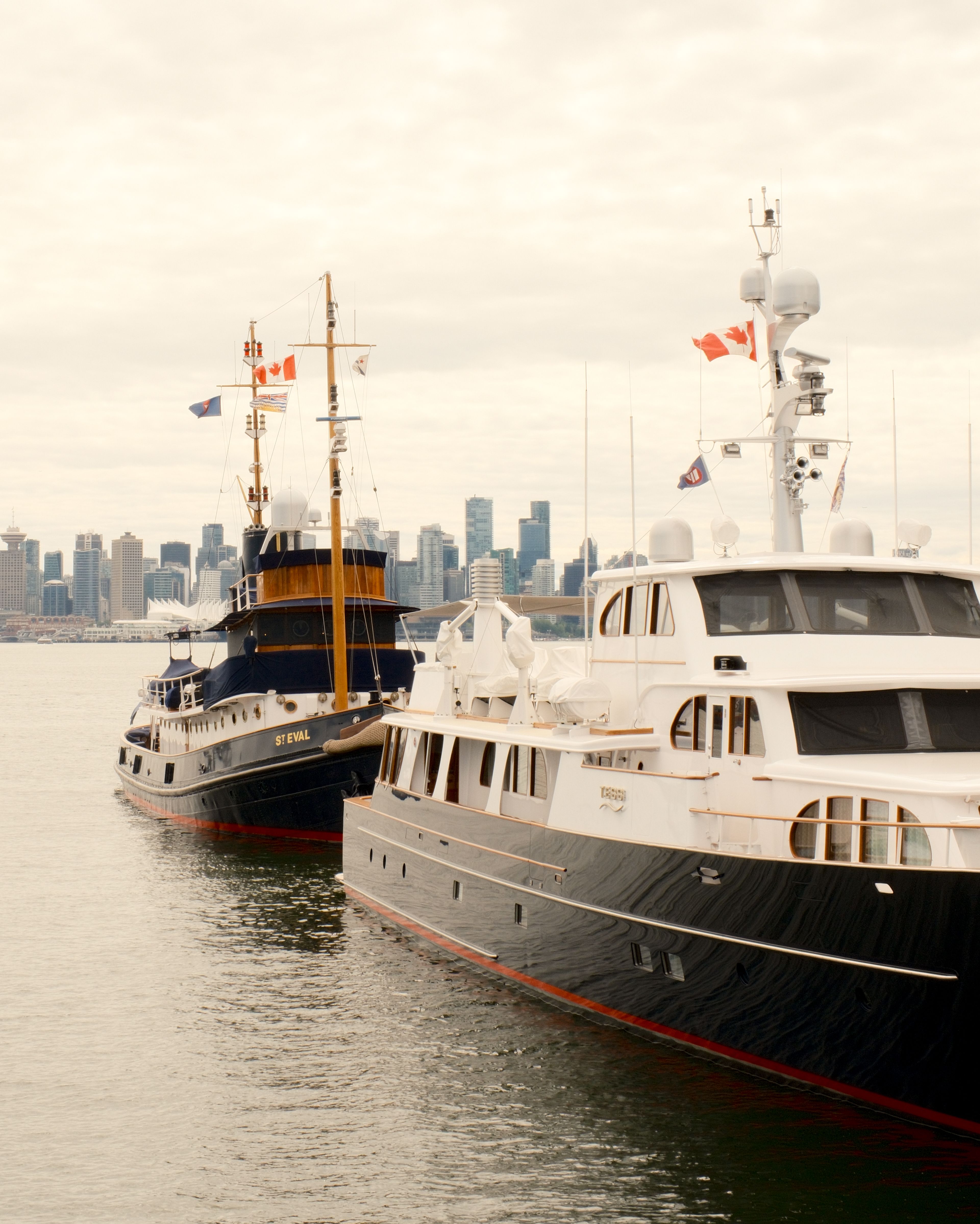 Elegant yachts docked in North Vancouver with the city skyline in the background.