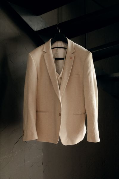 Sand-coloured linen-blend blazer on a hanger. Photo by Alexander Mass on Pexels