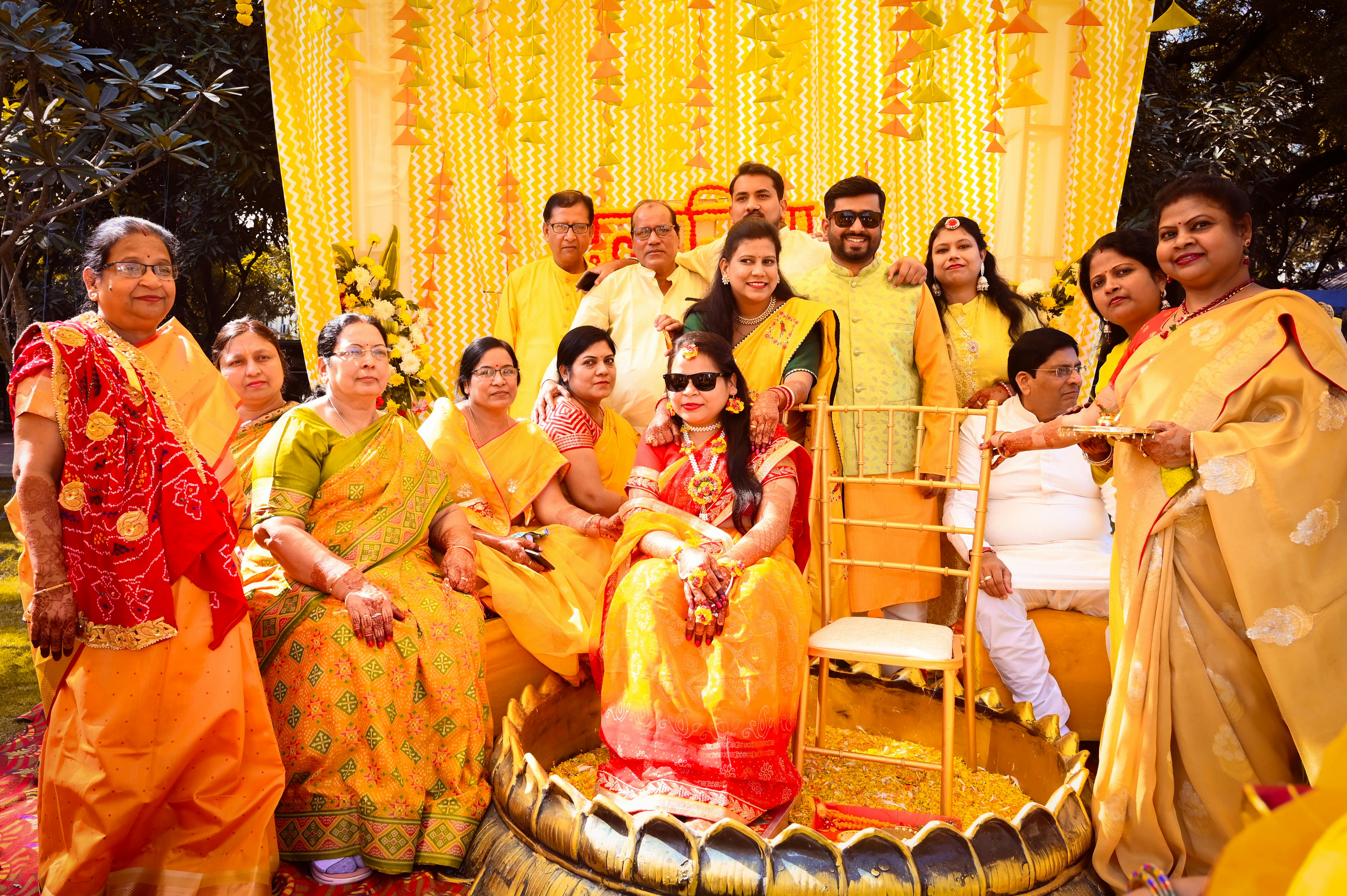Family gathers for joyful Haldi ceremony during a vibrant Indian wedding celebration.
