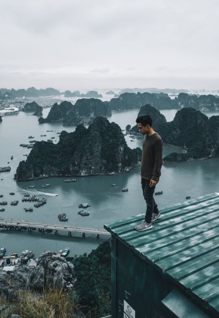 A man stands on a rooftop overlooking the stunning Ha Long Bay in Vietnam.