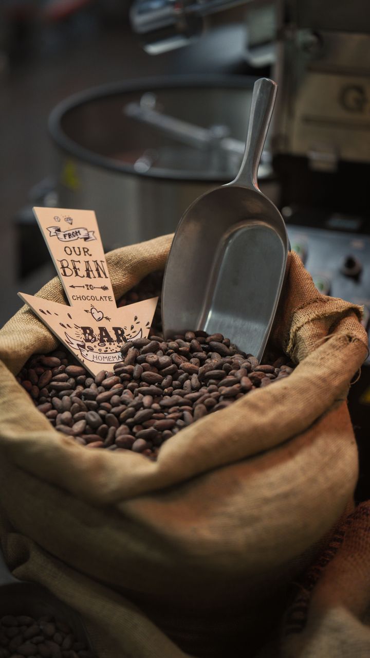 Burlap coffee bean bag displayed on a wooden stand next to an office coffee bar espresso machine