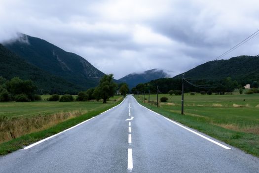 A picturesque road leading through the mountains in Castellane, Provence, France on a cloudy day.