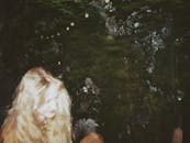 在一张双曝光照片中，一位美丽的年轻女子与郁郁葱葱的绿色自然背景融为一体