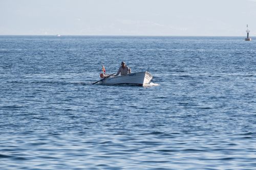 Free A peaceful scene of a small fishing boat on the calm Aegean Sea near Foça, Turkey. Stock Photo