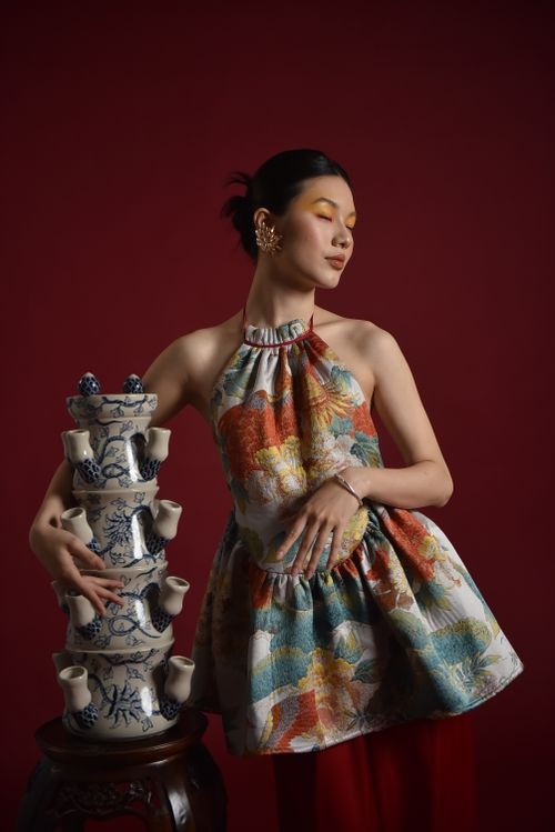 Free Stylish woman in a floral dress posing beside blue ceramic teapots Stock Photo