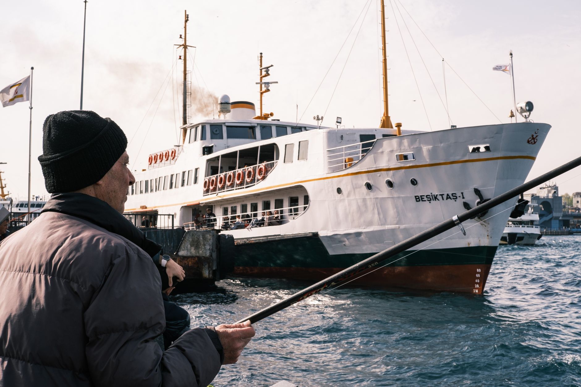 Elderly man fishing near the Beşiktaş ferry in Istanbul, Turkey.