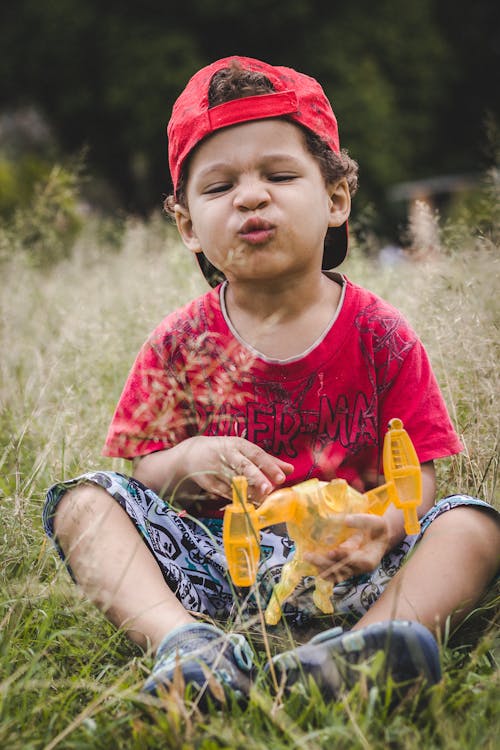 Фотография мальчика, сидящего на траве