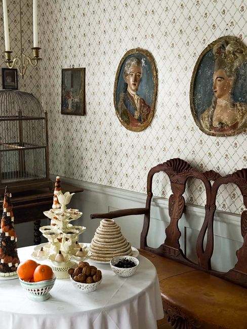 Elegant vintage dining room with decorative treats and antique portraits.