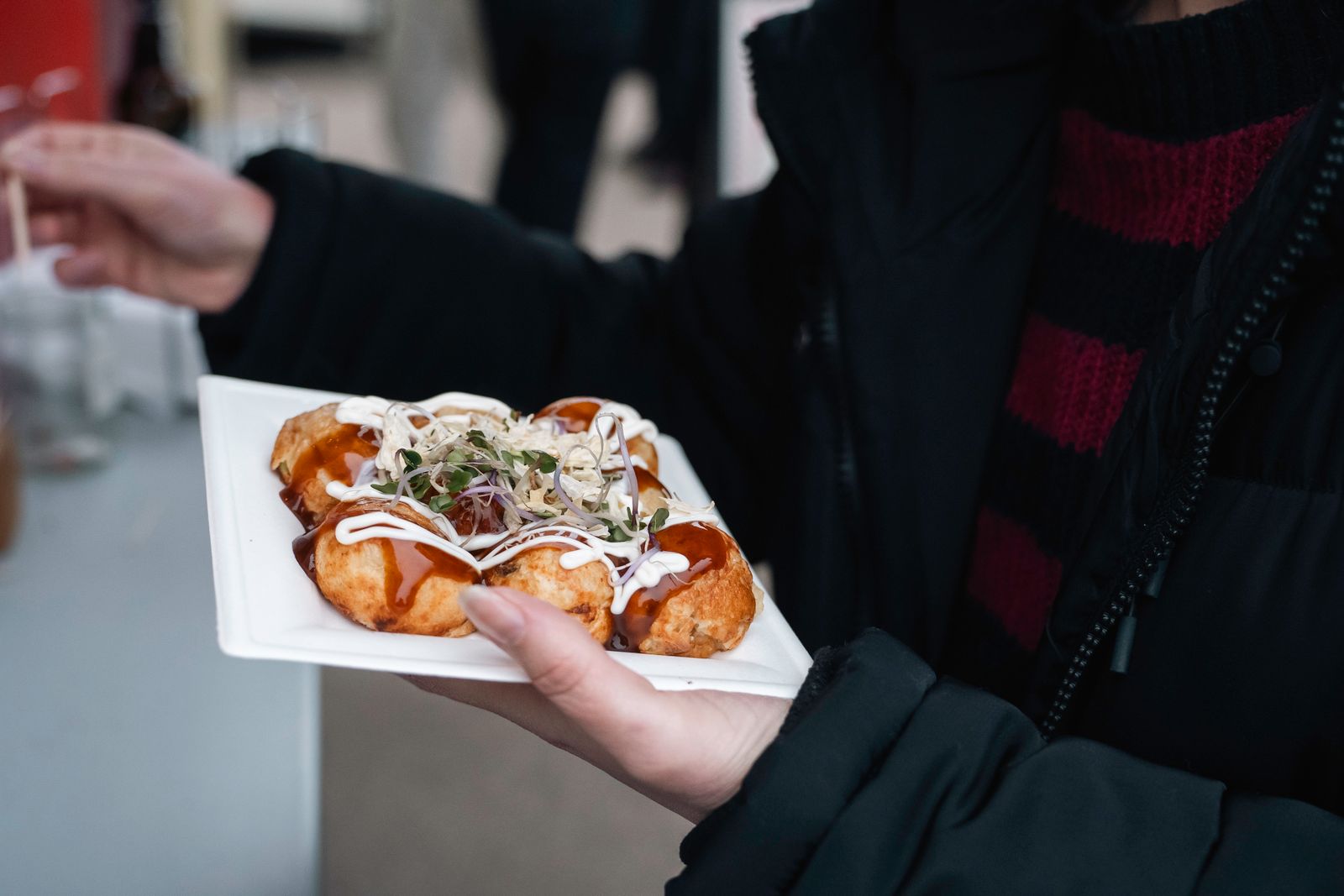 Goldgelbe Takoyaki-Bällchen brutzeln auf einem Grill