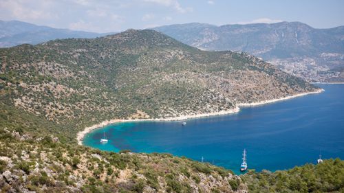 Free Breathtaking view of Mediterranean coastline with boats and lush green hills. Stock Photo
