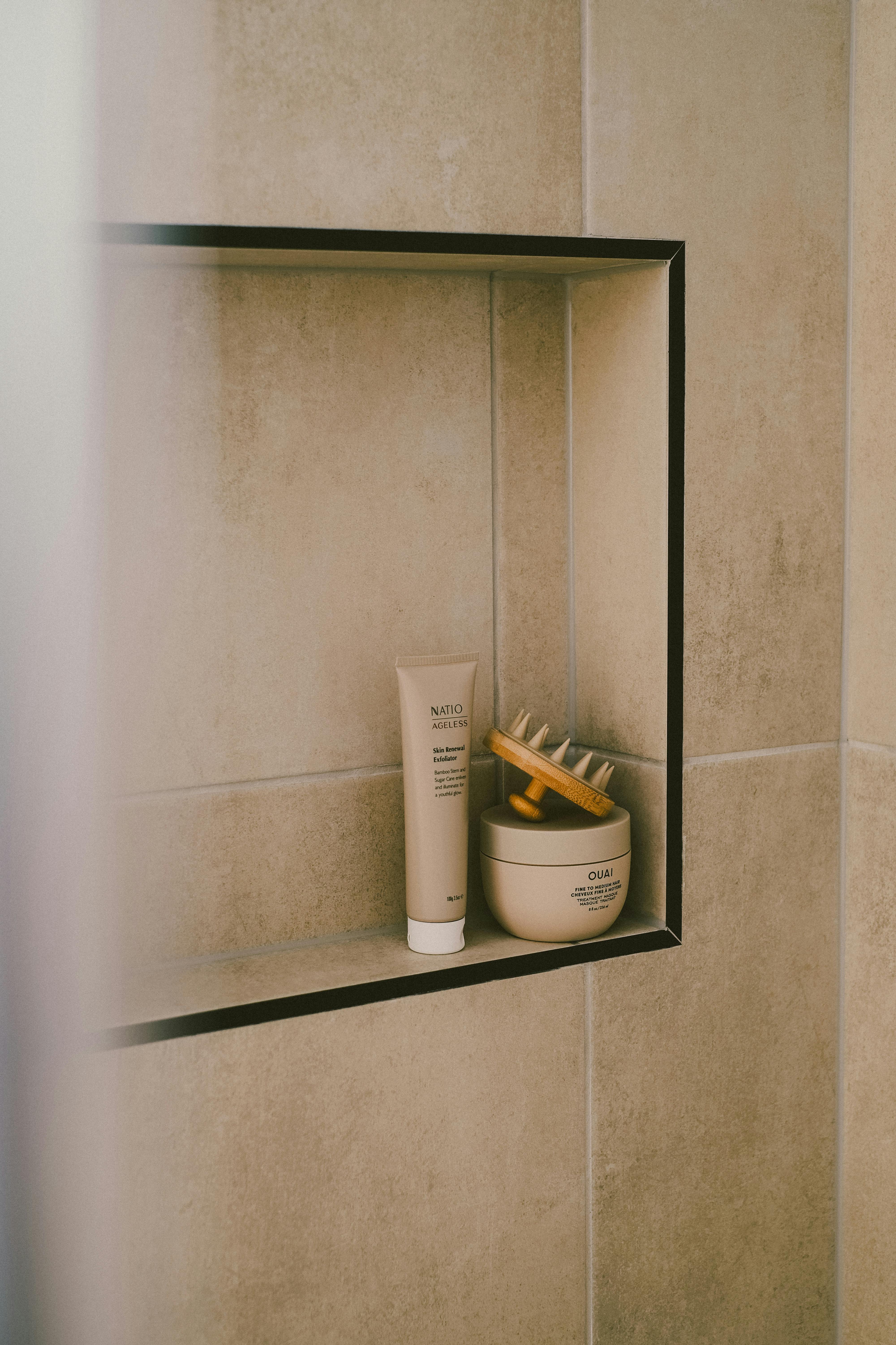 A modern bathroom shelf featuring minimalist beauty products and accessories, perfect for a self-care routine.
