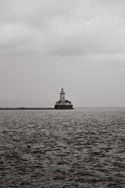 Free A black and white view of the Chicago Harbor Lighthouse against the vast Lake Michigan. Stock Photo